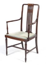 An Edwardian mahogany open armchair.