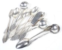 Thirteen Malaysian white metal spoons, two butter knives and a small pickles(?) fork.