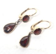 A pair of early 20th century gold and garnet pendent earrings.