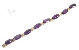 A gold-plated and oval amethyst-coloured paste eight stone bracelet,