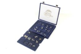 A blue velvet box with 24 pairs of silver earrings in many varied designs