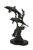 A patinated bronze sculpture of dolphins swimming underwater.