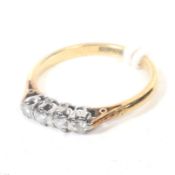 A mid-20th century gold and diamond four stone ring. The slightly graduated round brilliants approx.