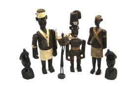 A group of African tribal figures, some with cowrie shell eyes. Max.