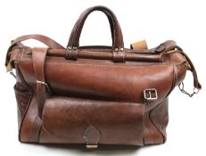 A tan leather weekend holdall bag. With handles and a detachable shoulder strap.