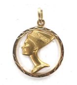 An Egyptian yellow metal pendant depicting a profile of Nefertiti.