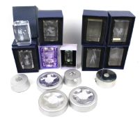 A collection of light boxes illuminating crystal ornaments. Featuring scenes of angels, women, etc.