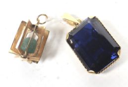 A middle Eastern synthetic sapphire pendant. The dark-blue rectangular step-cut stone approx.