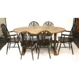 A vintage oak oval dining table and a set of six wheelback chairs.