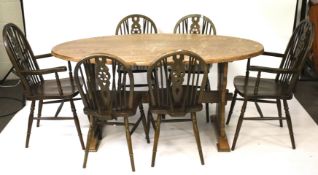 A vintage oak oval dining table and a set of six wheelback chairs.