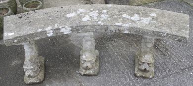 An ornamental stone garden curved bench. With three dolphin supports.