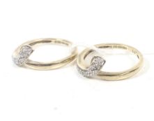 A pair of 9ct gold and diamond inter-changeable cross-over scroll rings.