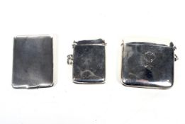 Two silver vesta or match cases and a match book holder.