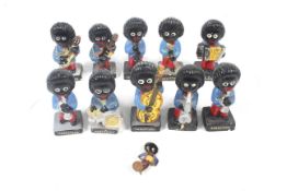 A collection of ten painted stoneware Robertson golly musician figures and one brooch.