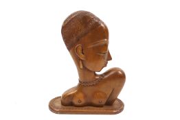 A mid-century carved hardwood African tribal sculpture of a young woman. On an oval plinth.