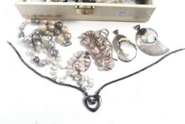 A collection of costume jewellery in a cream leatherette jewellery box.