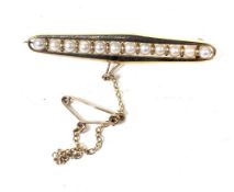 A vintage 9ct gold and cultured-pearl open bar brooch. The 12 3.