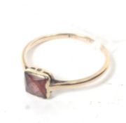 An early 20th century rose gold and square garnet single stone ring.