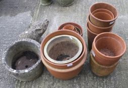 A collection of assorted garden pots. Mostly terracotta plus a stone piggy. Max.