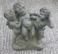 A vintage stone garden ornament of three cherubs.