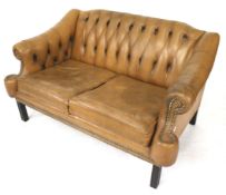 A vintage tan leather button back two seater settee.