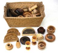 A collection of assorted turned wood and treen items in a wicker basket.