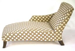 A contemporary chaise longue with spotted fabric upholstery.