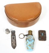 A small group of objects including a pale-blue glass scent bottle.