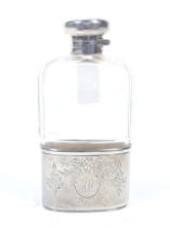 An early 20th century silver mounted facetted clear-glass spirit or hip flask,