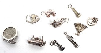 A collection of ten silver charms including a car; a boat;
