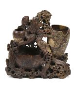A Chinese soapstone water pot. Carved with a phoenix and dragon and three variously sized pots.