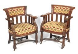 A pair of large open oak tub chairs.