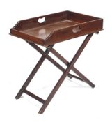 A mahogany butler's tray on a folding stand.