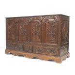 A carved oak coffer mule chest with three drawers.
