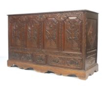 A carved oak coffer mule chest with three drawers.