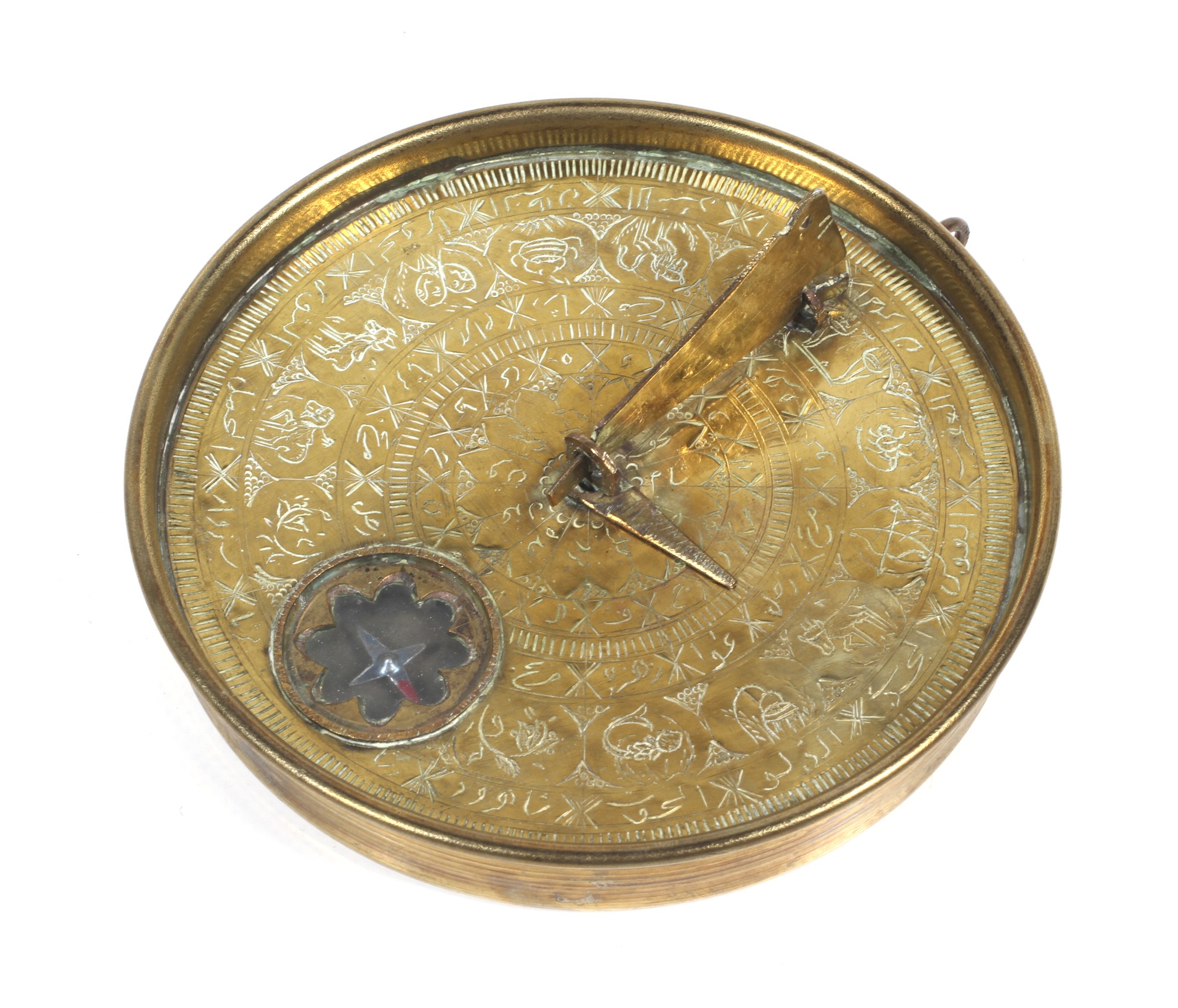 A brass Islamic sundial. Engraved with concentric borders including one with signs of the zodiac.