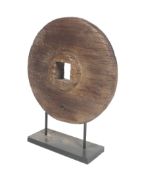 A contemporary art piece in the form of a carved circular wood cartwheel.