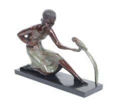 An Art Deco style resin figure of a woman feeding a parrot.