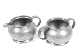 A hammered pewter Liberty style 'Tudric' strawberry set. Comprising a sugar pot and milk jug, Max.