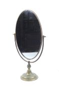 An early 20th century oval swing mirror on a round base.
