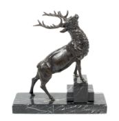 A cast metal stag mounted on a marble covered plinth.