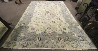 A mid-20th century hand made carpet/large rug with light sage green ground.