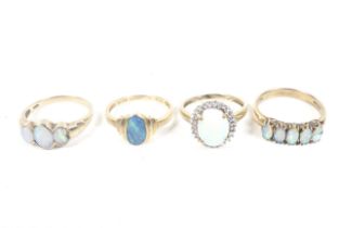 Four gold and opal rings including a 14ct gold and black-opal-doublet single stone ring.