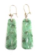 A pair of early 20th century gold and jadeite panel pendent earrings.