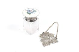 An early Victorian silver decanter label and a small silver and floral mounted smelling salts jar.