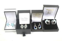 Four pairs of enamelled silver earrings.