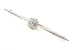 An early 20th century gold and diamond cluster bar brooch. The nine old-cut diamonds approx. 0.
