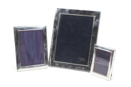 Three vintage silver-mounted graduated rectangular easel-back photograph frames.