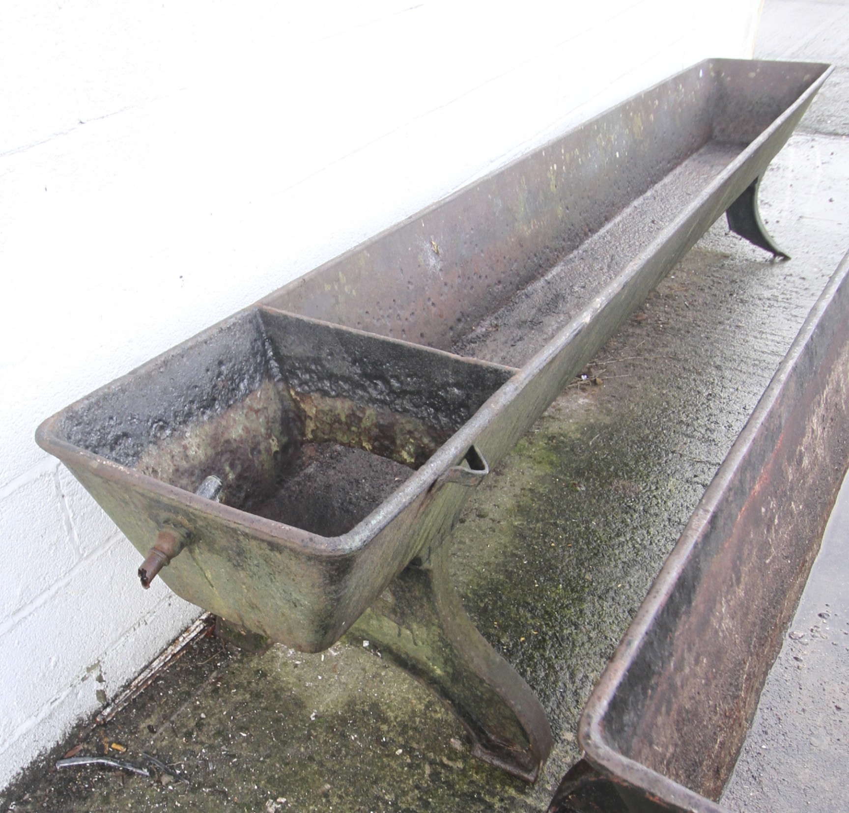 A 19th century large cast iron horse trough. Finished in black on bowed ...