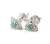 A pair of small small emerald and diamond flower-head quatrefoil cluster stud earrings.